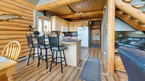 A log cabin interior with a kitchen, dining area, and a cozy living space. - Soldotna Fishing Lodges w/ Dock on Kenai River! (Soldotna)