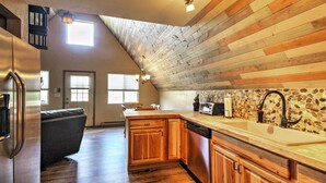 A kitchen with wooden cabinets, a dishwasher, a stove, and a stone backsplash. - Hillside Cripple Creek Cabin w/ Hot Tub, Mtn Views (Cripple Creek)