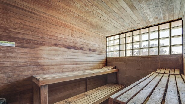 A sauna room with wooden benches and a large window.