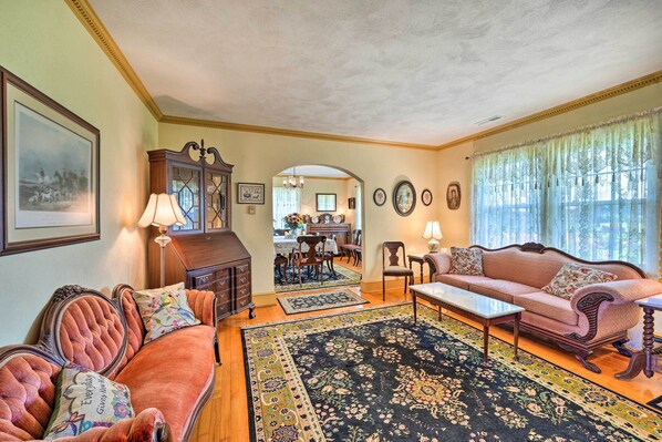 A traditional living room with a sofa, armchairs, a coffee table, and a dining area in the background. - Family Getaway w/ Pier on Currituck Sound (Currituck)
