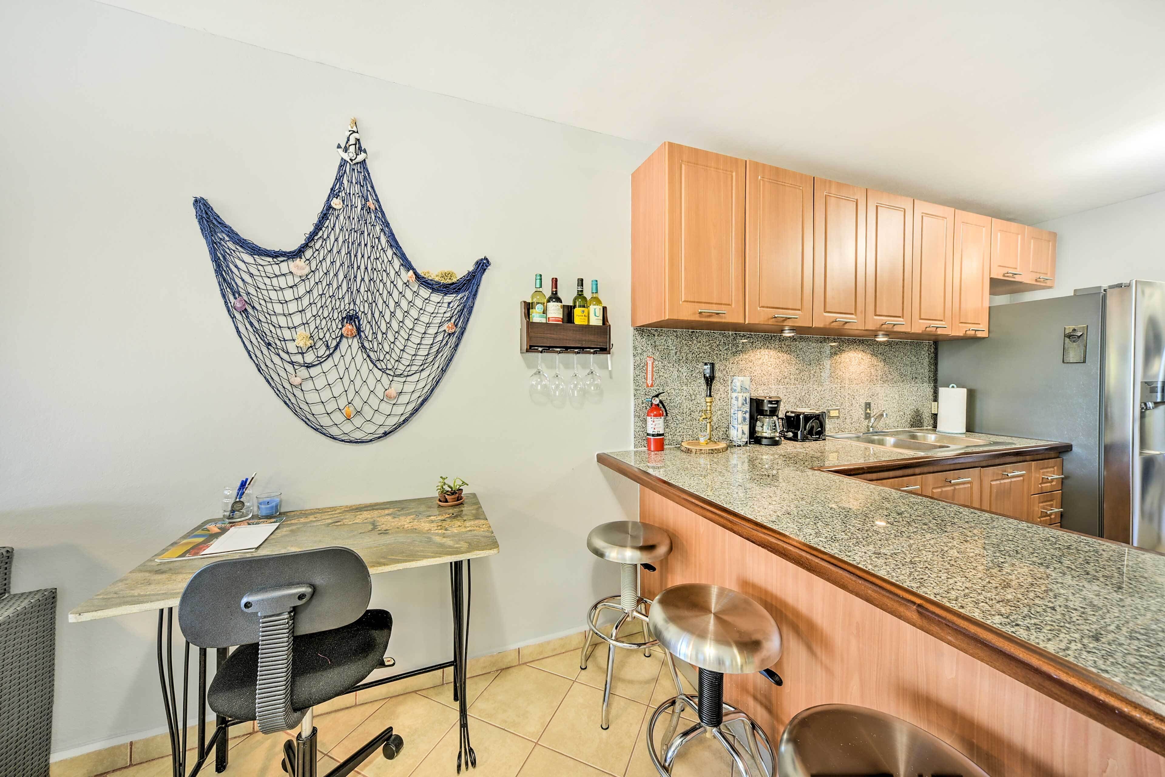 A modern kitchen with wooden cabinets, a granite countertop, and a hanging decorative net.