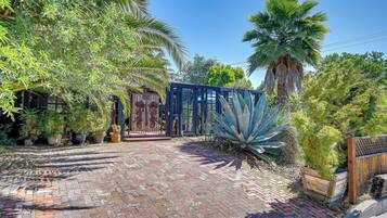 Stroll through the garden to a serene conservatory with a view of lush greenery and palm trees.