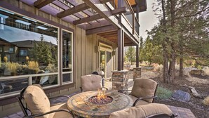 An outdoor patio with a fire pit, seating, and a view of a modern building. - Modern Eagle Crest Escape w/ Patio & 2 Balconies! (Redmond)