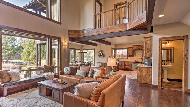 A spacious living area with a high ceiling, large windows, and a view of the outdoors. - Modern Eagle Crest Escape w/ Patio & 2 Balconies! (Redmond)