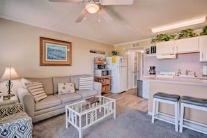 A compact living space with a kitchenette, a sofa, a coffee table, and a dining area. - Beachfront Isle of Palms Condo w/ Balcony & Pool! (Isle of Palms)