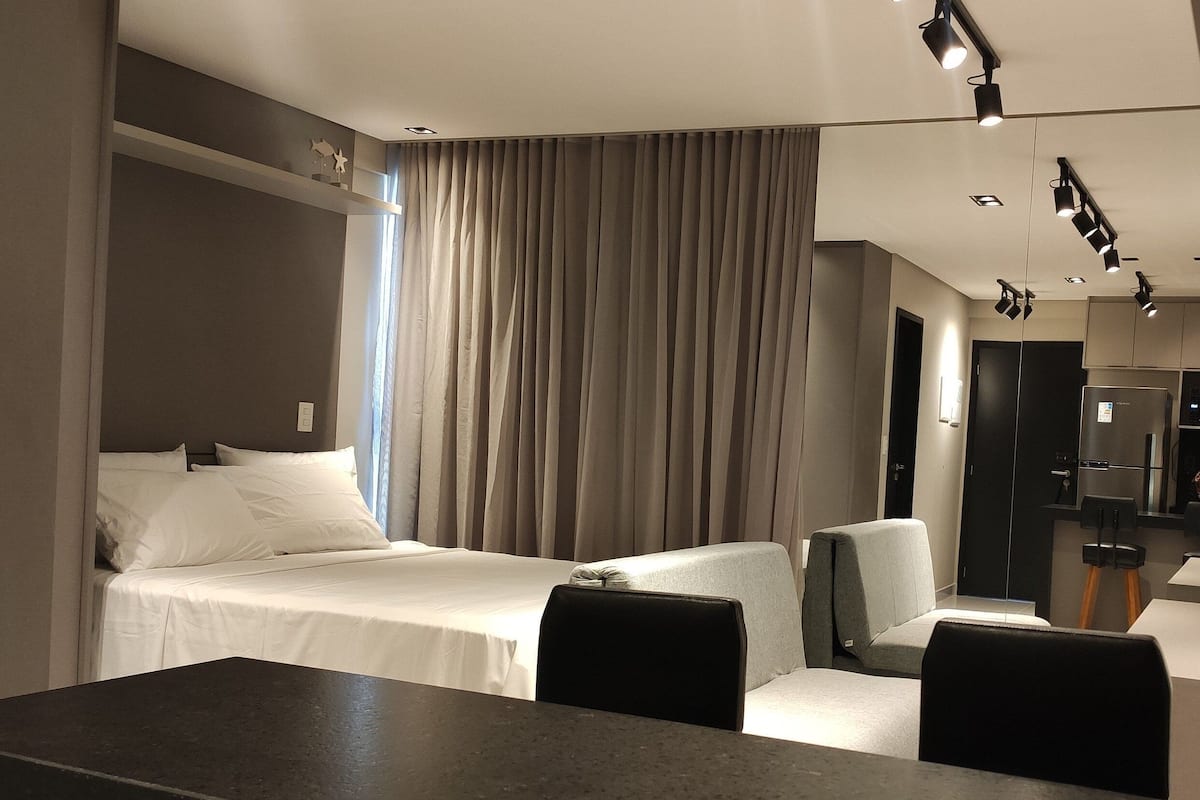 Une chambre d’hôtel moderne équipée d’un lit, d’un bureau et d’un coin salon.