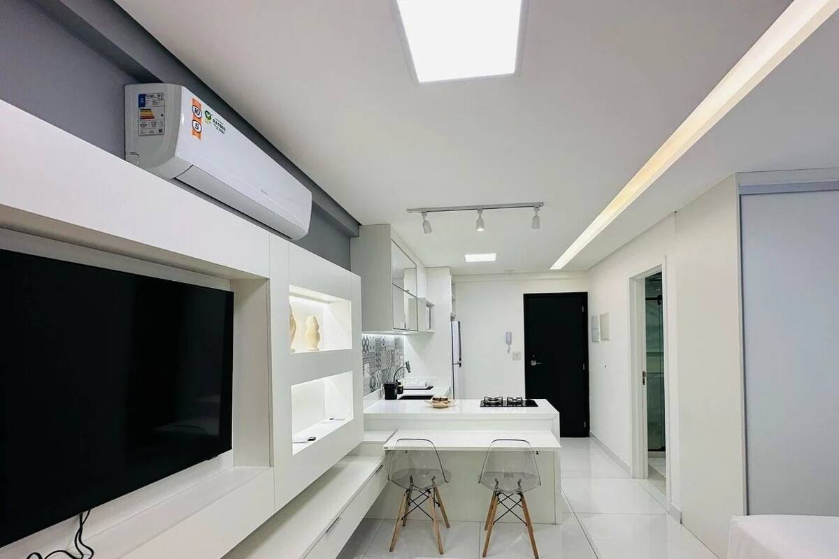 Une cuisine moderne dotée d’un grand îlot central, de meubles blancs et d’une verrière.