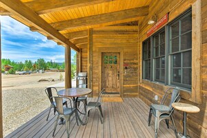 A wooden exterior with a covered patio, a wooden door, and a sign reading "WOODY'S BUNKHOUSE".