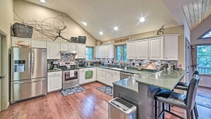 Una cocina moderna con armarios blancos, electrodomésticos de acero inoxidable y una isla grande.