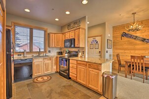 A modern kitchen with wooden cabinets, a stainless steel refrigerator, and a built-in oven.