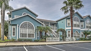 A two-story building with a white picket fence, a palm tree, and a clear sky. - Kissimmee Family Home! Community Pool + Playground (Kissimmee)