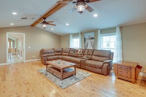 Relax in this spacious living room with a high ceiling and comfortable seating area.