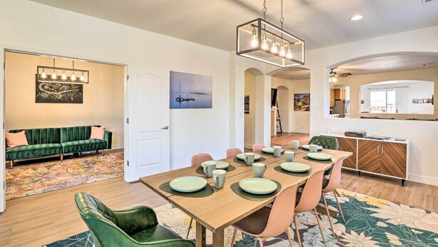 A dining area with a wooden table set for six, surrounded by green and pink chairs. - 12 Mi to Riverwalk District: Quiet Reno Retreat (Reno)