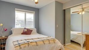 A bedroom with a bed, a bedside table with a lamp, a window, and a sliding door closet. - 12 Mi to Denver: Golden Vacation Rental! (Golden)