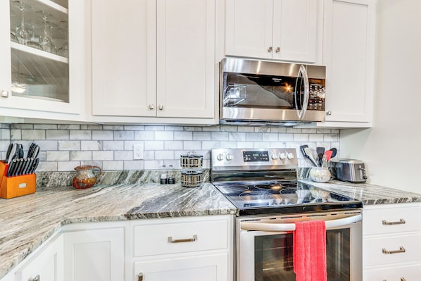 A kitchen with white cabinets, a stainless steel oven, a microwave, and a granite countertop. - Deck, Fire Pit & Fireplace: Murphy Forest Retreat (Murphy)