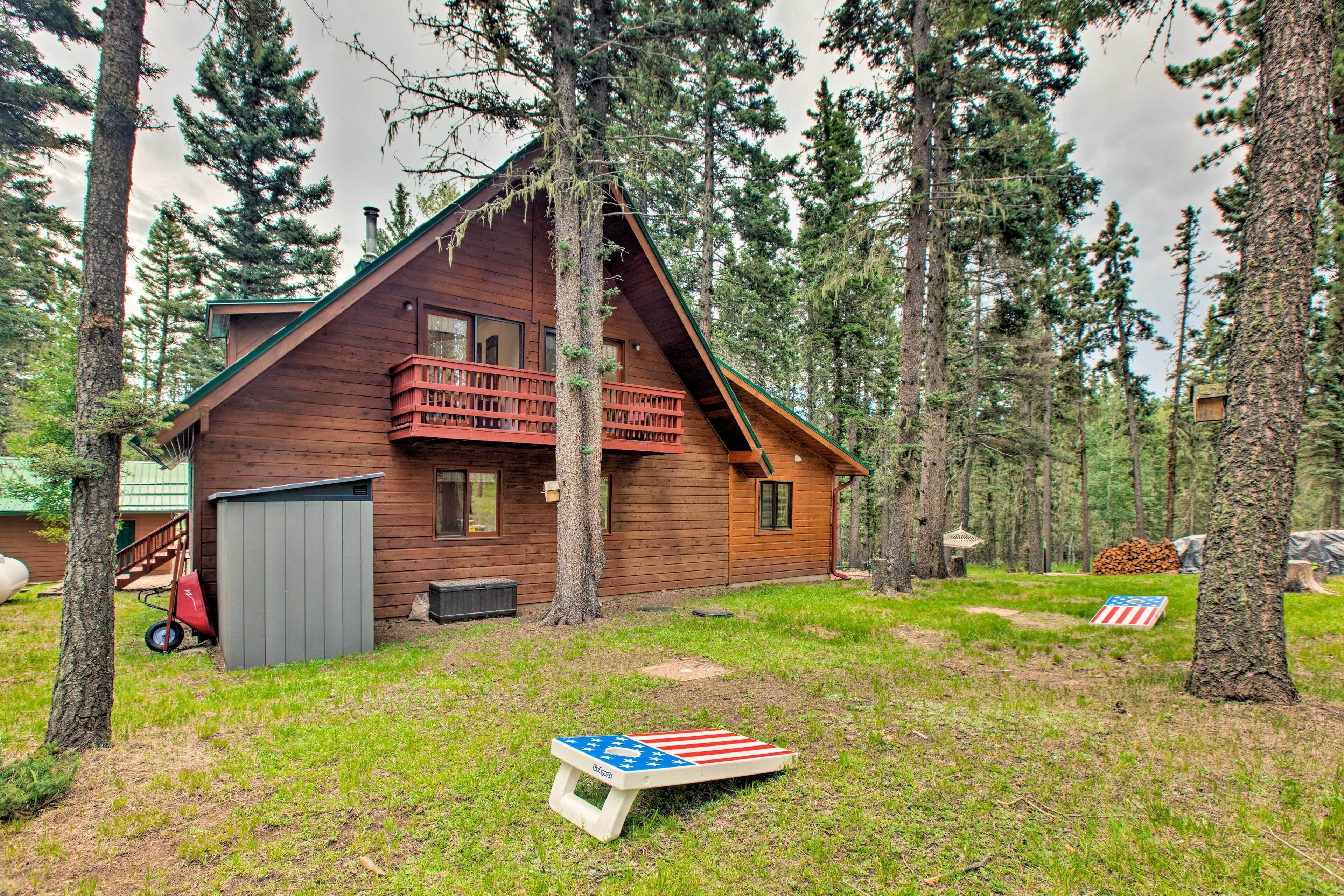 A cabin with a wooden exterior, a balcony, and a small deck.