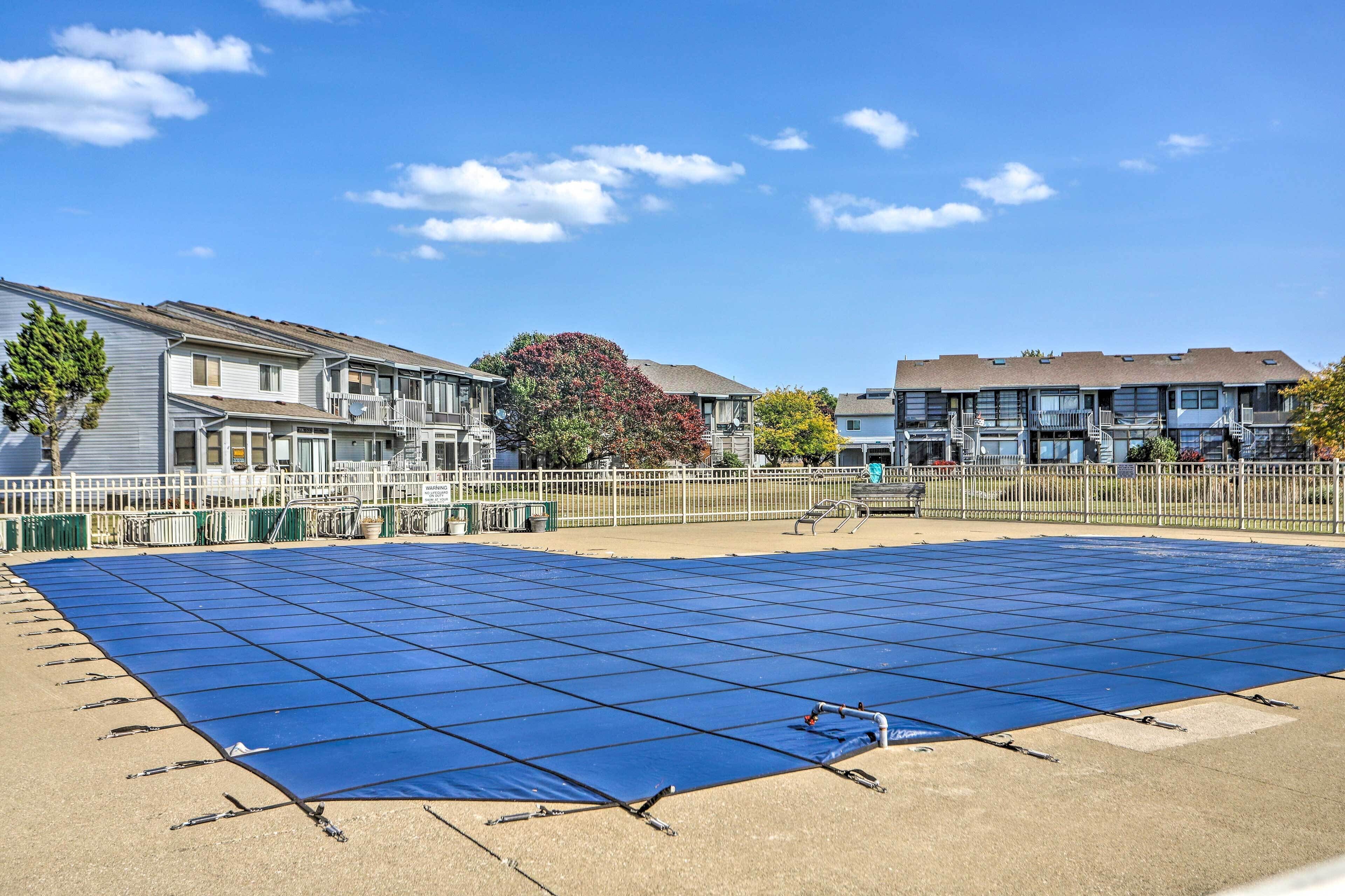 Een groot buitengebied met een groot veld blauwe zonnepanelen, omringd door appartementencomplexen.