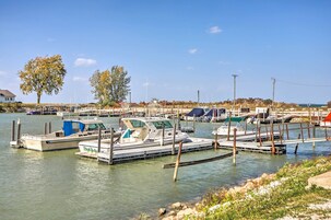 Ένα λιμάνι με αρκετά σκάφη αγκυροβολημένα, καθαρός ουρανός και λίγα δέντρα στο βάθος.
