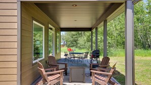 A covered patio with a table and chairs, a grill, and a view of a grassy area. - Creek Access + Fire Pit! Red Lodge Family Retreat (Red Lodge)