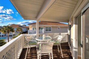 A covered patio with wicker furniture and a view of a swimming pool and neighboring houses. - < 1 Mi to Ocean: North Myrtle Beach Condo (North Myrtle Beach)