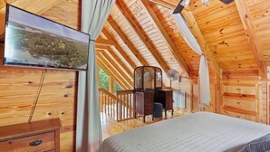 A wooden cabin bedroom with a bed, dresser, and a TV mounted on the wall. - Lakefront Keowee Home w/ Dock, 14 Mi to Clemson (Seneca)
