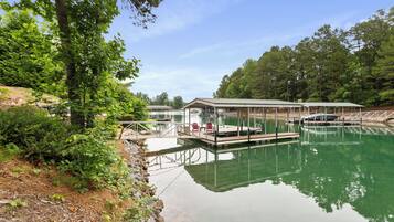 A tranquil lakeside setting with a dock, covered seating area, and a small pavilion.