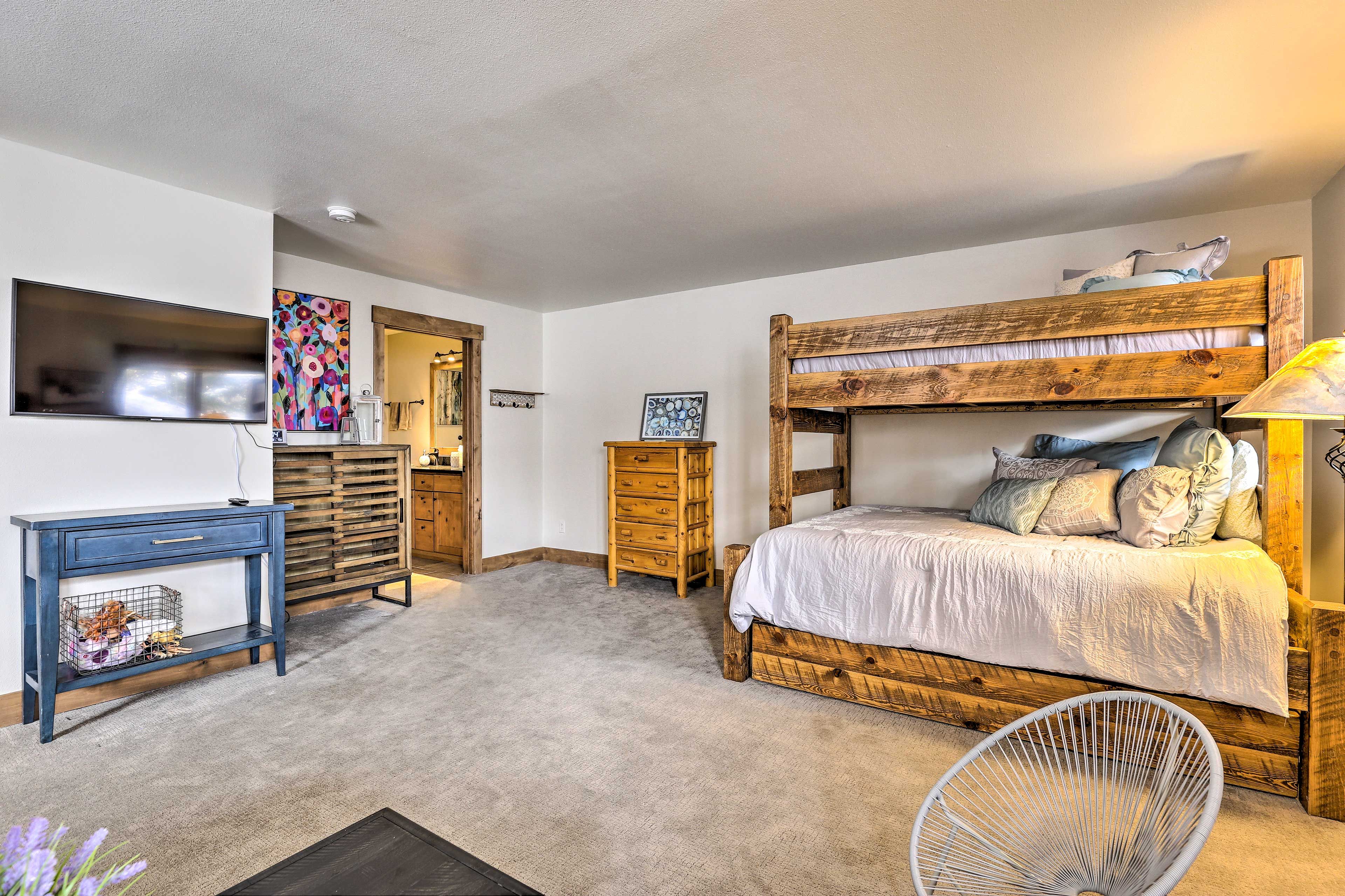 A bedroom with a bunk bed, a desk with a chair, a dresser, and a mirror.