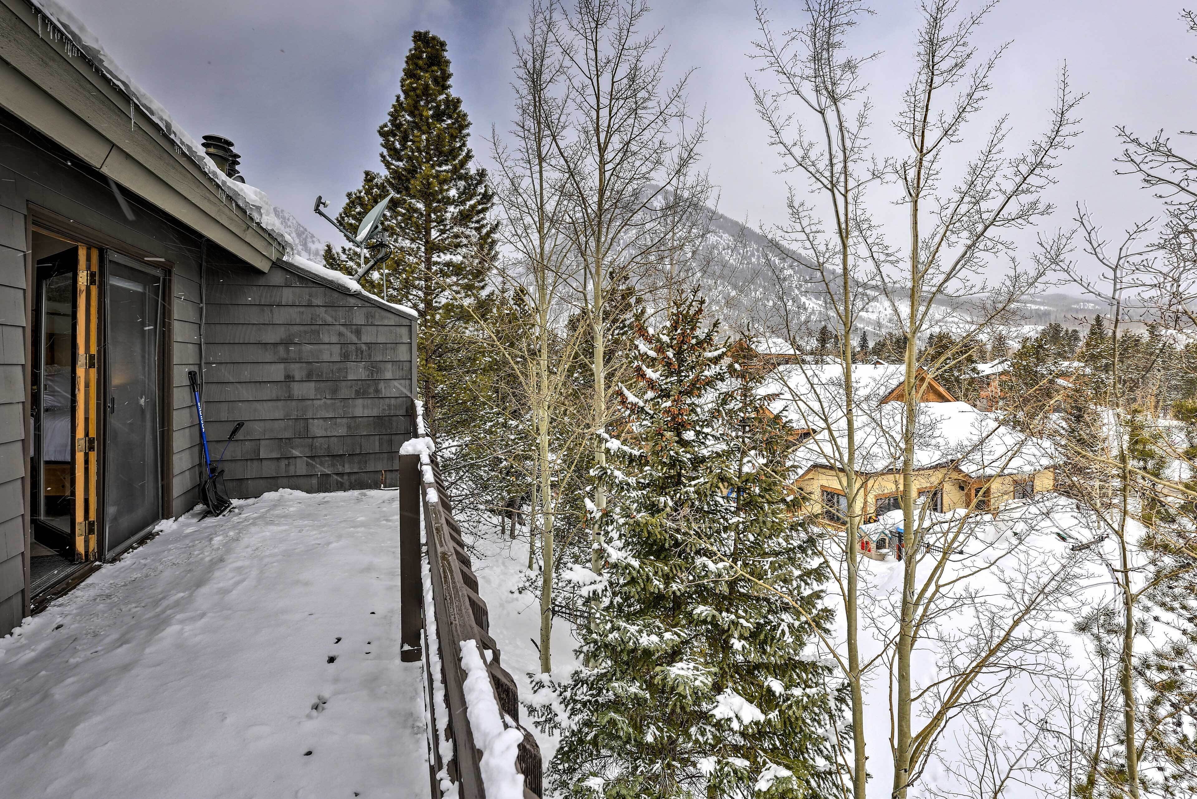 Ein mit Schnee bedecktes Holzhaus mit sichtbarer Tür und einem verschneiten Dach.