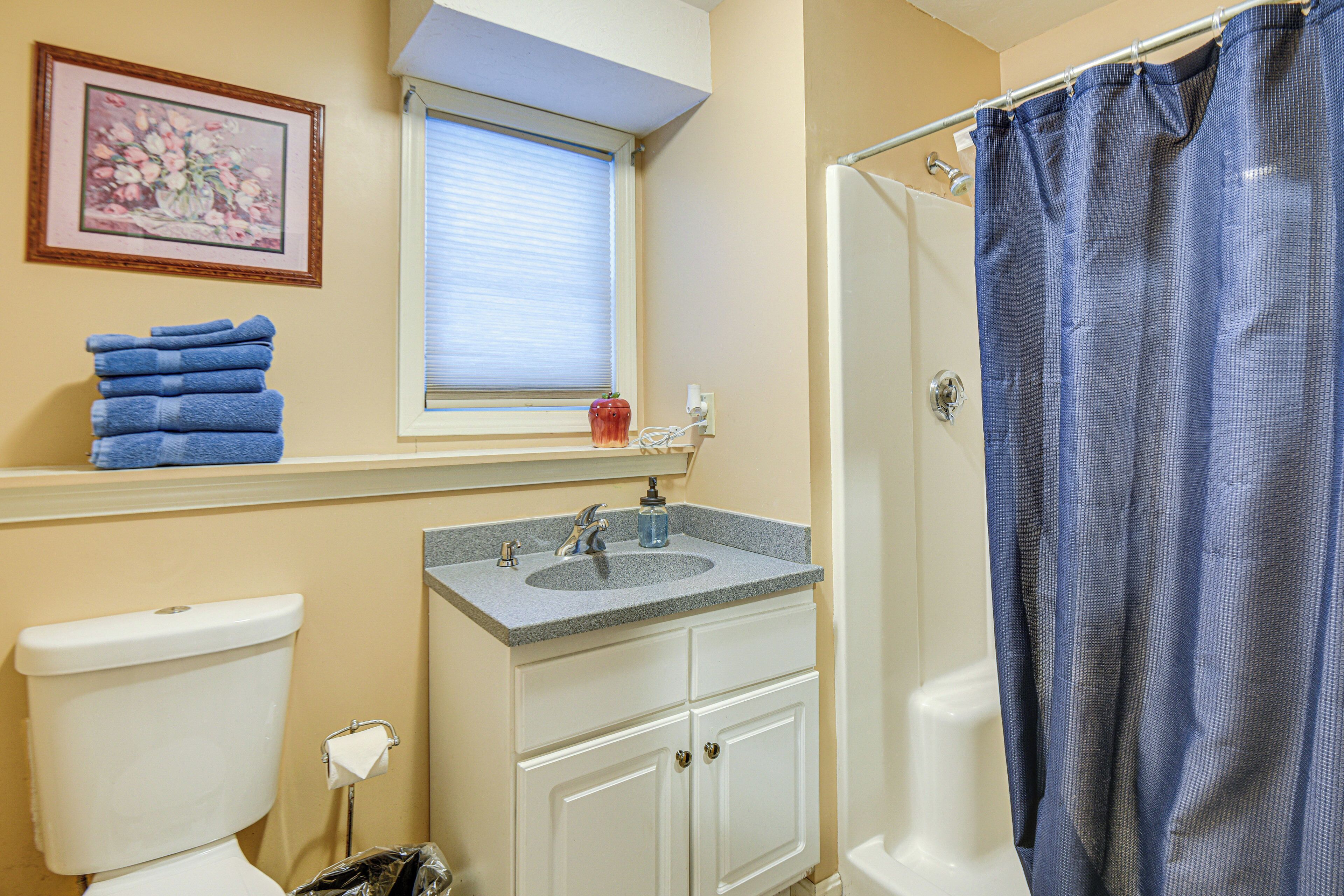 A bathroom with a toilet, sink, and shower curtain.