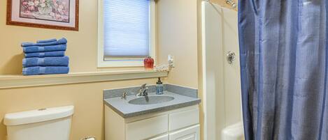 A bathroom with a toilet, sink, and shower curtain.