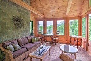 A wooden deck with a wicker sofa, a table, and chairs. - Home w/ Fire Pit, 7 Mi to Attitash Mtn Resort (Jackson)