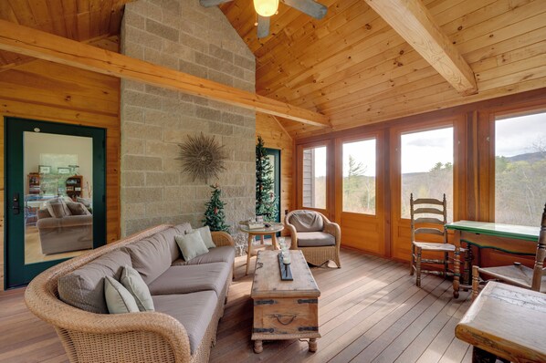 A wooden interior with a sofa, chairs, a table, and a fireplace. - Home w/ Fire Pit, 7 Mi to Attitash Mtn Resort (Jackson)