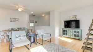 A living room with a sofa, chairs, a coffee table, a TV, and a cabinet. - Seabrook Getaway w/ Balconies & Bay Views! (Seabrook)