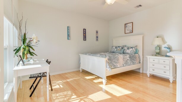 A bedroom with a bed, a desk, a chair, a nightstand, and a ceiling fan. - Seabrook Getaway w/ Balconies & Bay Views! (Seabrook)