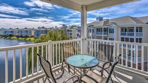 A balcony with a table and chairs overlooking a body of water and a row of buildings. - 3 Mi to Beach & Golf: Resort Condo in Myrtle Beach (Myrtle Beach)