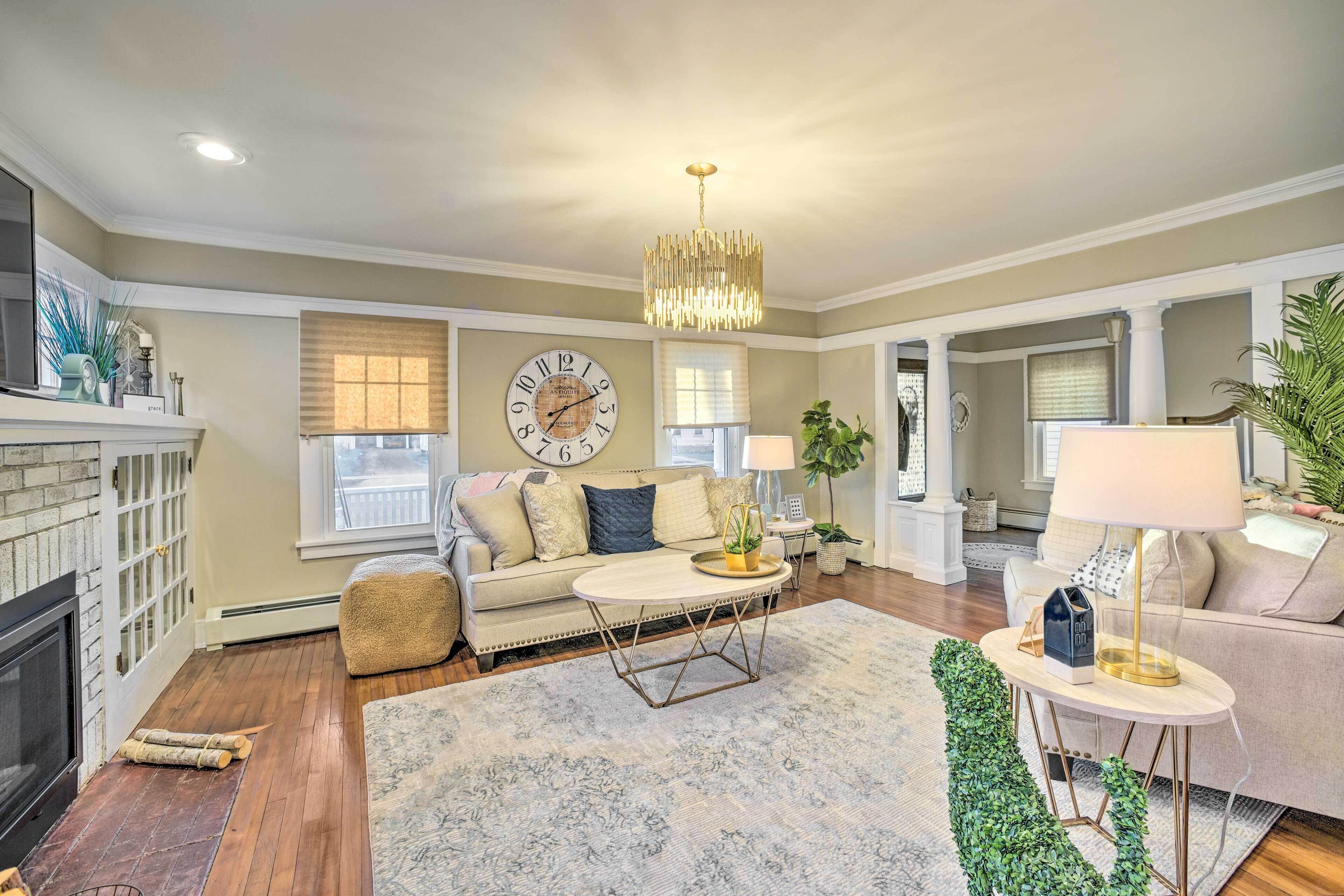 A living room with a fireplace, a sofa, a coffee table, and a chandelier.
