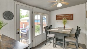 A dining area with a wooden table, four chairs, a ceiling fan, and a welcome sign. - Family-friendly Glens Falls Home w/ Sun Porch (Glens Falls)