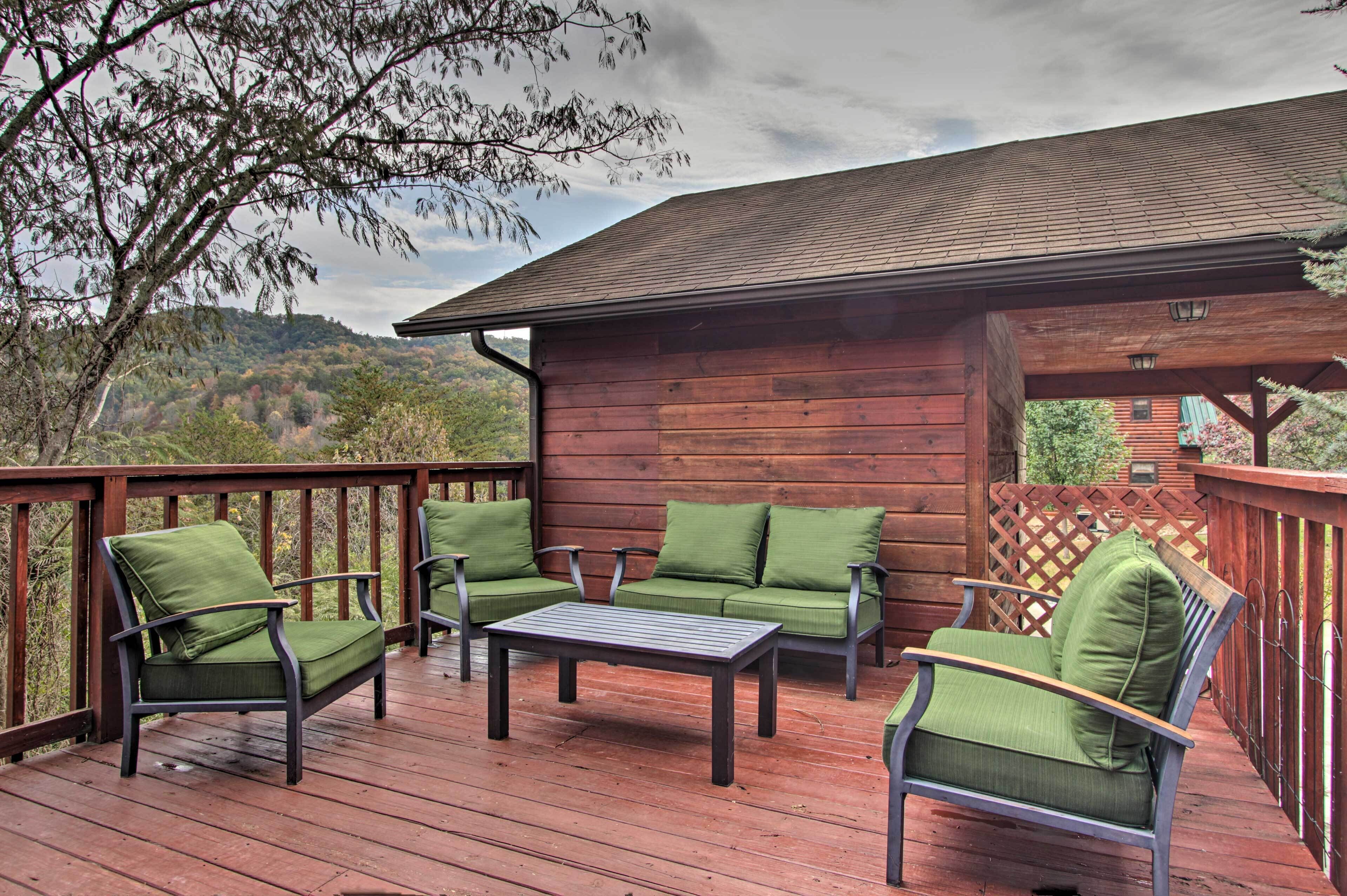 Une terrasse en bois, aménagée avec du mobilier d’extérieur, notamment des chaises et une table, et offrant une vue sur un paysage pittoresque.