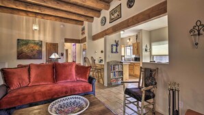 A cozy living room with a red velvet sofa, a wooden coffee table, and a rustic ceiling. - 1 Mi to Santa Fe Plaza: Quiet Home w/ Patio (Santa Fe)