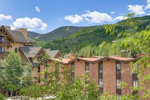 A multi-story building with a brick facade, large windows, and a balcony. - Updated Condo: Walk to Vail Village & Ski Shuttle! (Vail)