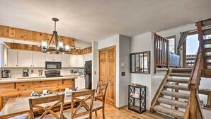 Una cocina moderna con armarios de madera, una isla central y una lámpara de araña.