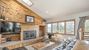 Una sala de estar acogedora con chimenea, televisor grande y zona de estar confortable.