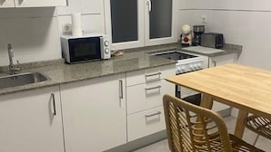 A kitchen with white cabinets, a microwave, a toaster, and a stove. - 102B Poniente Mágico by R2R Consulting (Gijón)