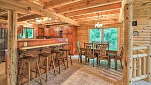 A log cabin interior with a kitchen, dining area, and bar.
