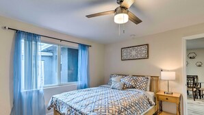 A bedroom with a bed, a nightstand, a ceiling fan, and a window with curtains. - Inviting Apartment < 2 Mi to Riviera Beach! (West Palm Beach)