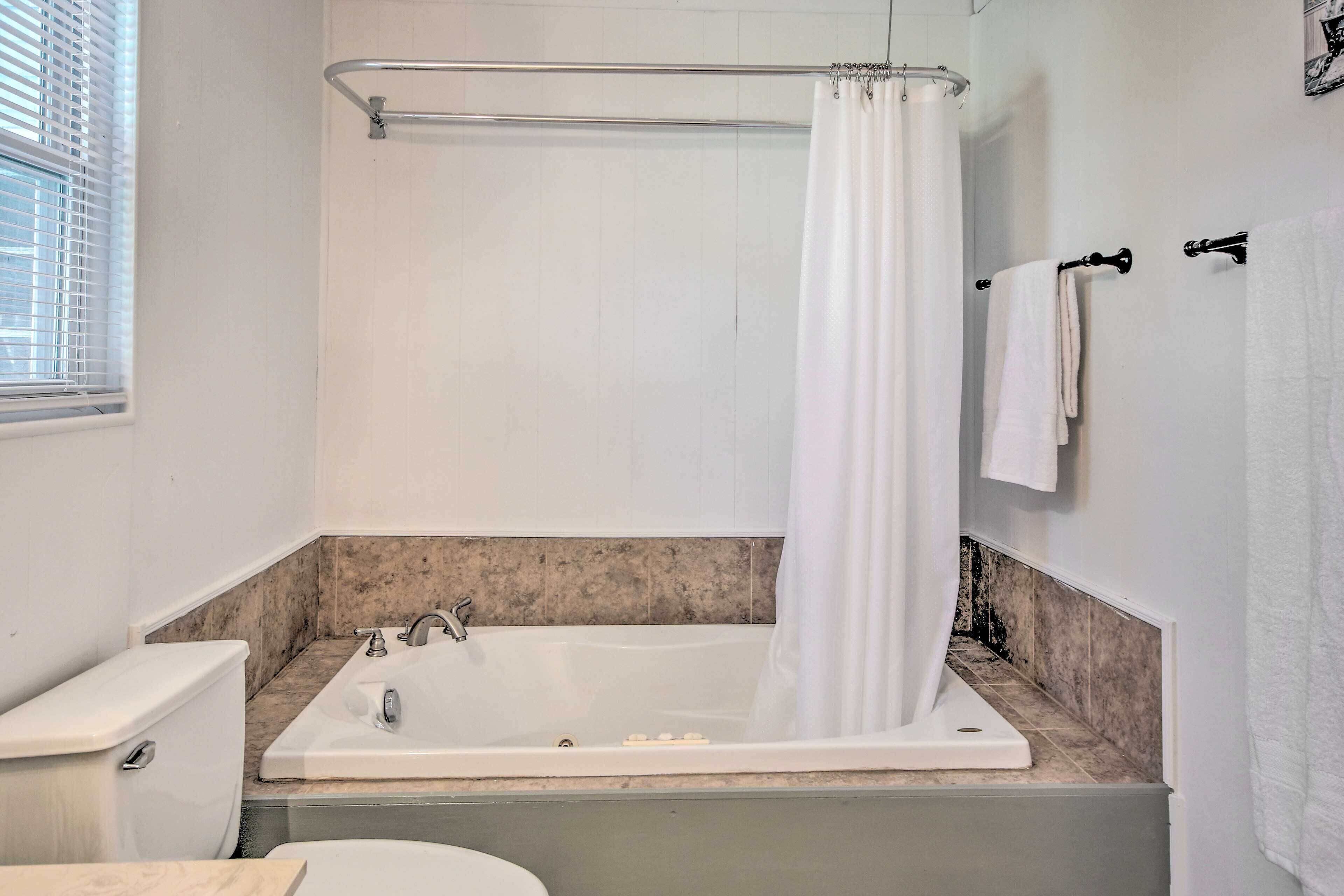 A bathroom with a bathtub, toilet, and sink.