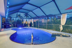 A swimming pool with a geometric roof structure and string lights. - Punta Gorda Canal Home w/ Private Pool! (Punta Gorda)