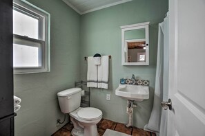 A bathroom with a toilet, sink, and window. - Palm Harbor Vacation Rental, Walk to Crystal Beach (Crystal Beach)