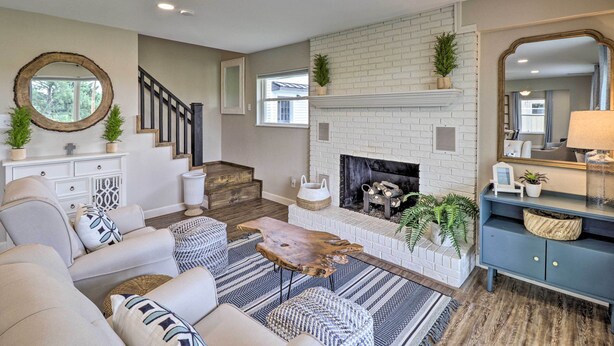 A living room with a fireplace, sofas, a coffee table, and a staircase.