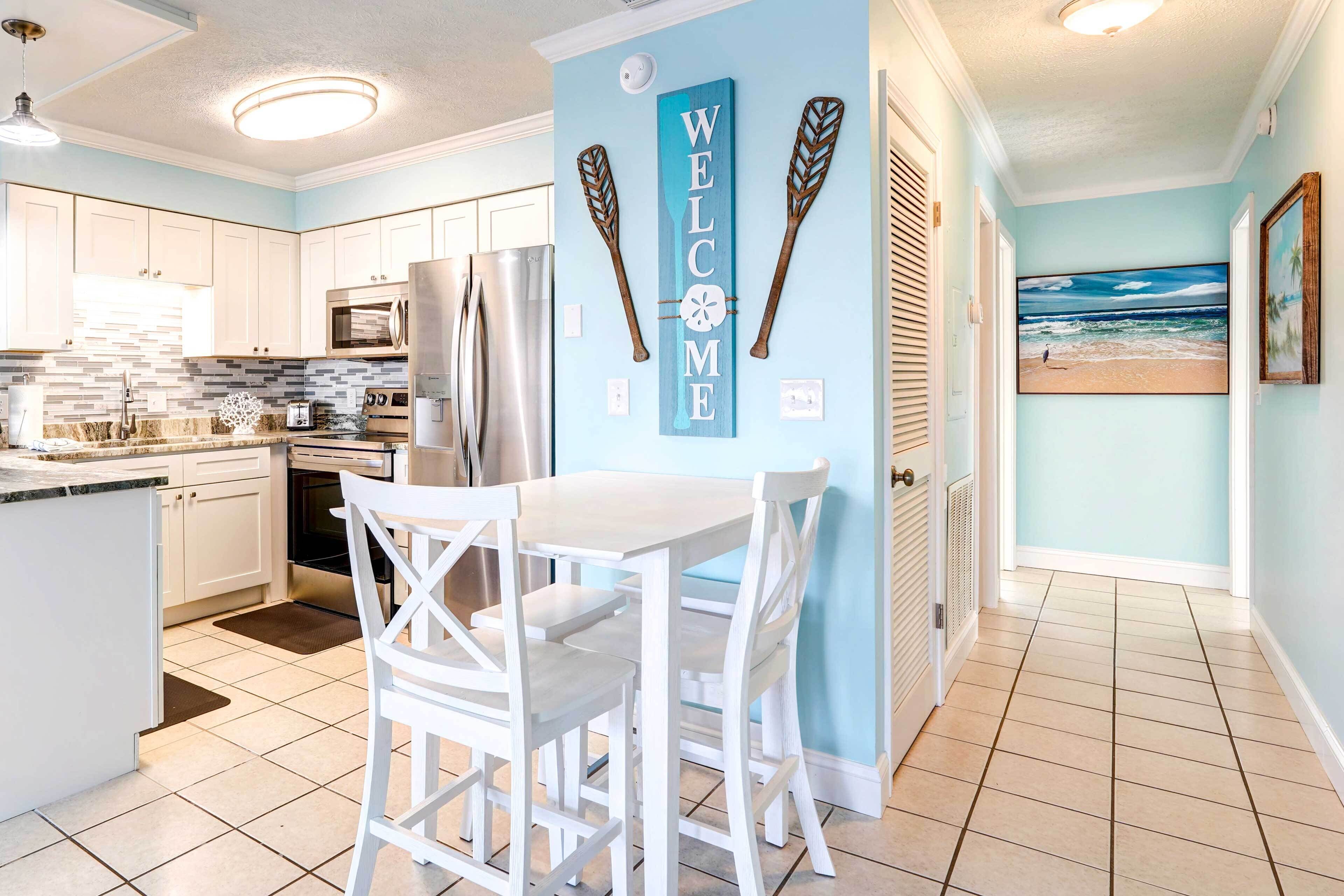 A kitchen with white cabinets, a stainless steel refrigerator, and a tiled backsplash.